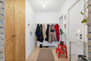 a hallway with a red chair and a closet at Great central apartment walking distance to metro in Copenhagen