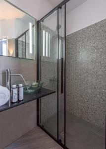 a bathroom with a glass shower with a sink at Armenakishouses in Pollonia
