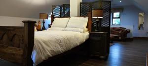 1 dormitorio con 1 cama grande y cabecero de madera en The Garden Gates Guest Accommodation, en Castlebar