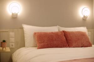 ein Schlafzimmer mit einem Bett mit zwei Lichtern an der Wand in der Unterkunft Το Σπίτι της Ευτυχίας Σουίτα in Karpenisi