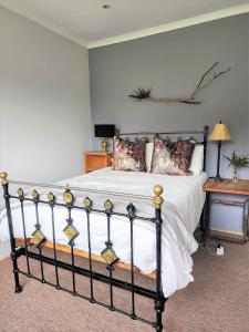 1 dormitorio con 1 cama y 1 mesa con lámpara en Serena Cottage, en Nottingham Road