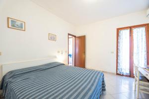 a white bedroom with a bed and a desk at Casa Luppoli in Portoferraio