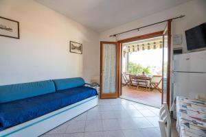 a living room with a blue couch and a sliding glass door at Casa Luppoli in Portoferraio