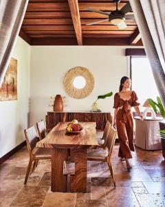 een vrouw die in een woonkamer met een tafel loopt bij Hacienda AltaGracia, Auberge Resorts Collection in Santa Elena