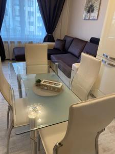 salon ze szklanym stołem i krzesłami w obiekcie Iva Luxury Apartament w mieście Ruse