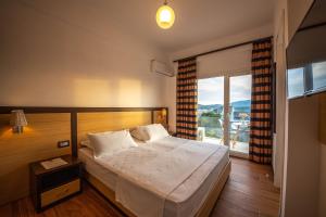a bedroom with a bed and a large window at Inada Rooms Ksamil in Ksamil