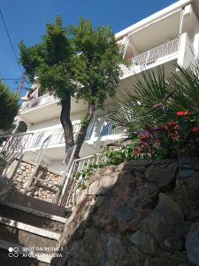 a white house with stairs and trees in front of it at OLGA apartmani in Sutomore