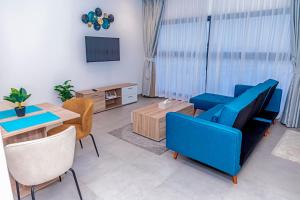 a living room with a blue couch and a table at Waypoint Suites in Dakar