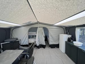 Bredebro的住宿－Bredebro camping，一个带椅子和桌子的帐篷以及一台冰箱