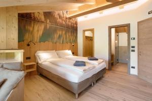Agriturismo Bosco d'oro 5 في ليفينو: غرفة نوم بسرير كبير ولوحة على الحائط