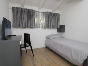 una camera con letto e scrivania con sedia di Palma Residence - Villino LA QUERCIA a Marco Simone