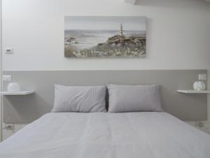 una camera bianca con un letto bianco e un faro di Palma Residence - Villino LA QUERCIA a Marco Simone