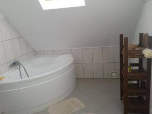 a white bathroom with a tub and a sink at Dom letniskowy Puńsk in Puńsk