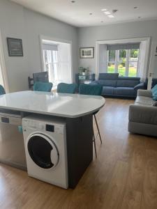 a kitchen and living room with a washing machine at Wellington Cottage in Wexford