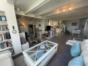 ein Wohnzimmer mit einem Sofa und einem Tisch in der Unterkunft Perla - cabin by the sea close to sandy beaches in Sandefjord