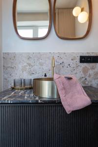 ein Waschbecken mit einem rosa Handtuch und einem Spiegel in der Unterkunft Odit in Brügge