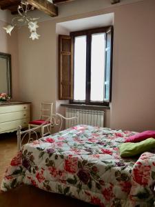 a bedroom with a bed and a dresser and a window at A Casa di Marzia in Rapolano Terme