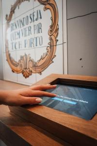 a hand is reaching into a wooden box with a cell phone at The Central House Porto Ribeira in Porto