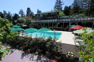 a swimming pool with umbrellas and a resort at The Woods Hotel - Gay LGBTQ Cabins in Guerneville