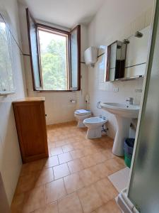 baño con lavabo y aseo y ventana en Casa per Ferie Ulivo d'Assisi, en Asís