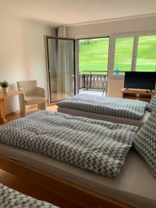 - une chambre avec 2 lits et une fenêtre avec un ordinateur portable dans l'établissement Bed and Breakfast Darlux, à Bergün