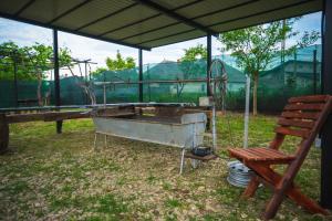a metal tub sitting under a tent next to a wooden bench at Glamping La Octav in Tîrpeşti