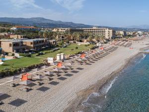 een luchtzicht op een strand met stoelen en appartementen bij Aquila Rithymna Beach in Adelianos Kampos