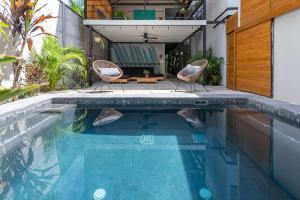 a swimming pool with two chairs and a house at Ventura Santa Teresa in Santa Teresa Beach