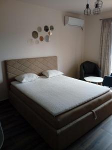 a bedroom with a large bed and a chair at Apartment Petra in Tivat