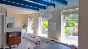 a living room with a blue ceiling and windows at ‘t Wirdummer Hof - family-friendly guesthouse in Wirdum