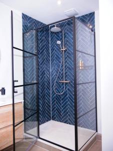 une douche avec un mur carrelé bleu dans l'établissement ‘t Wirdummer Hof - family-friendly guesthouse, à Wirdum