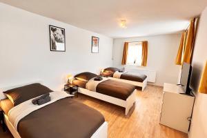 Zimmer mit 3 Betten und TV in der Unterkunft Chic Apartments - Smart-TVs in Stemshorn