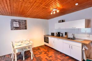 una cocina con armarios blancos y una mesa con sillas. en Chic Apartments - Smart-TVs en Stemshorn
