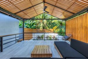 a balcony with a wooden pergola and a bench at Ventura Santa Teresa in Santa Teresa Beach