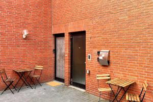 una pared de ladrillo con mesas y sillas junto a una puerta en Chic Apartments - Smart-TVs en Stemshorn