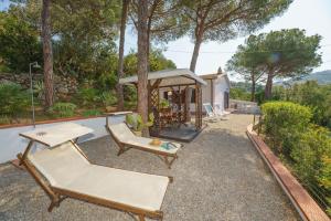 un patio trasero con cenador y sillas y una casa en Villino Luciana, en Capoliveri