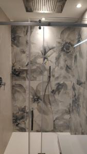 un bagno con box doccia e parete in marmo. di Hotel Ascot Riccione a Riccione