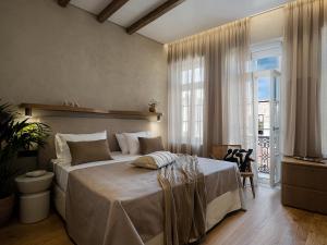 um quarto com uma cama grande e uma janela grande em Casa Modiano Boutique em Chania Town