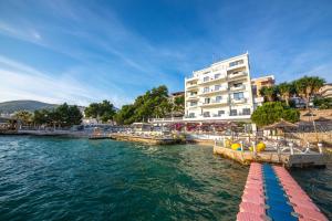 un hotel en el agua junto a un edificio en Hotel Jaroal, en Sarandë