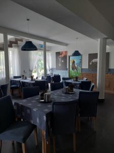 una sala da pranzo con tavoli blu e sedie blu di Hédervári Lovas Vendégház a Hédervár