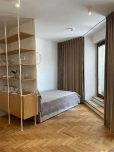 sypialnia z łóżkiem i półką na książki w obiekcie Wip Appartament Solec rezidencia w Warszawie