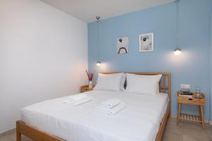 a bedroom with a white bed with two towels on it at Vouliagmeni Stylish Homes by BluPine in Athens