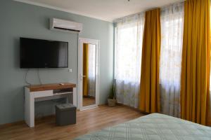 a bedroom with a flat screen tv and a bed at City Center Apartment in Burgas
