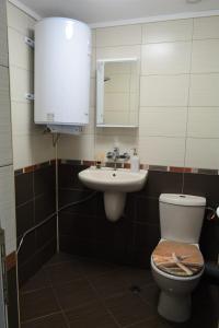 a bathroom with a sink and a toilet and a mirror at City Center Apartment in Burgas