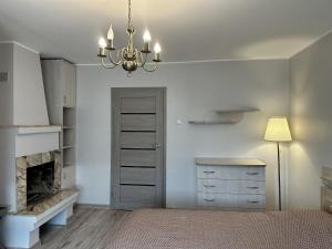 - une chambre avec une cheminée, un lit et un lustre dans l'établissement Central, à Panevėžys