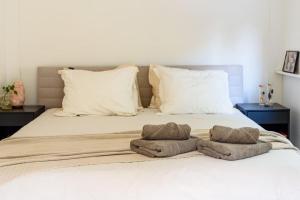 ein weißes Bett mit zwei Handtüchern darauf in der Unterkunft Rustgevend Paradijs aan het Bos in Putten