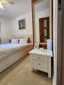 a bedroom with a bed and a mirror and a table at Краткосрочная посуточная аренда Бат-Ям! in Bat Yam