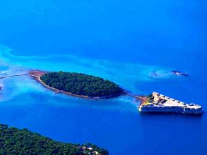 an island with a boat in the water at Central Sibenik Apartments in Šibenik