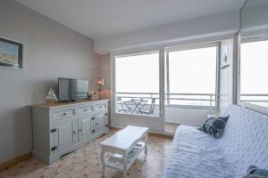 ein Wohnzimmer mit einem Sofa und einem TV in der Unterkunft Les Marinas in Courseulles-sur-Mer