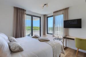 a bedroom with a bed and a desk with a television at Villa Chiara by SeeAdria Agency in Brtonigla +81 photos